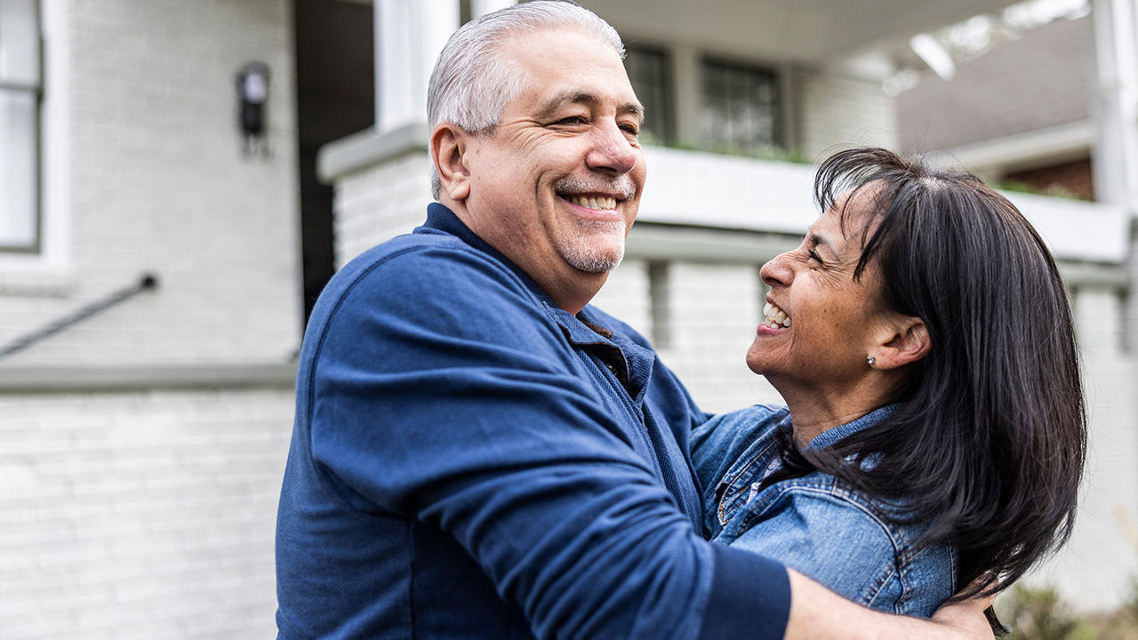 Smiling man and a woman hugging.