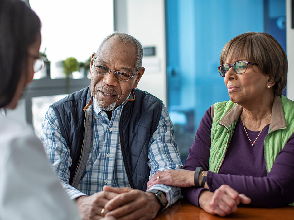 Man and woman seated listening to a physician.