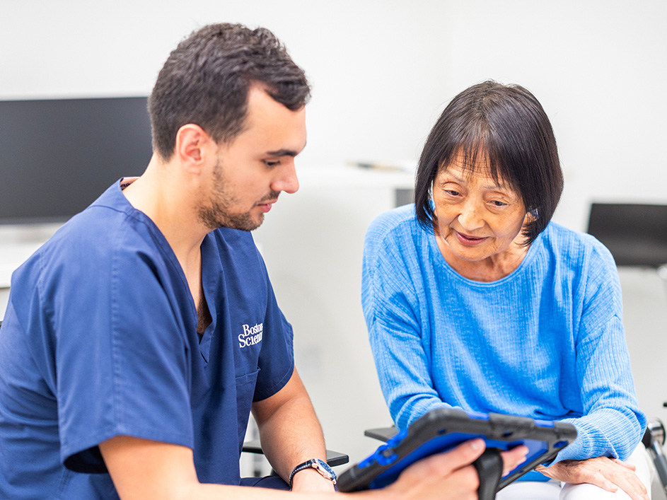 Health care provider and an older woman looking at a tablet.