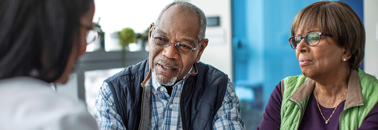 older couple talking to a healthcare professional.
