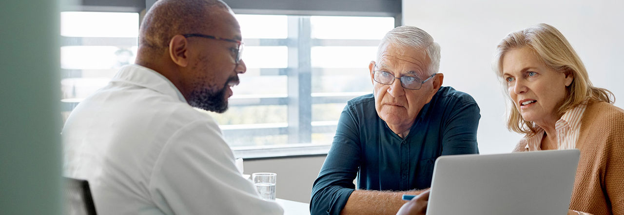 Older man and middle-aged woman listening to a physician.